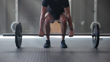 man lifting a barbell in a gym