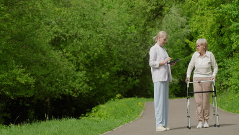 caregiver assisting elderly woman in a park