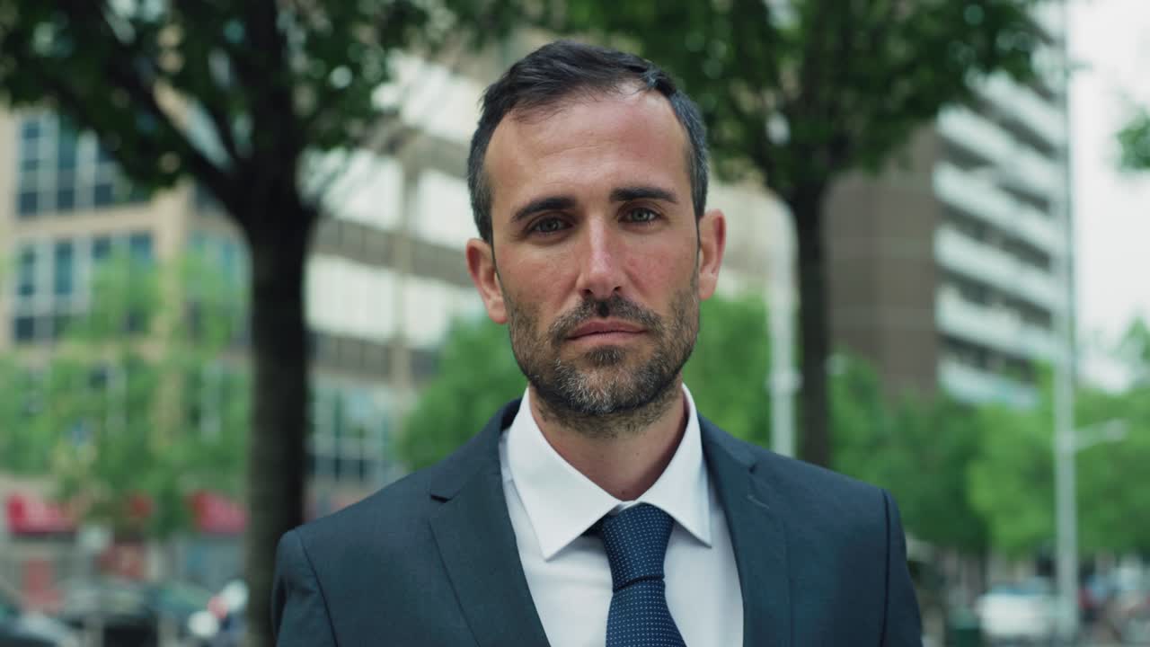 toma cinematográfica de un joven hombre de negocios feliz sonriendo a la cámara satisfecho con su día de trabajo en el parque de la ciudad por el camino a casa. concepto de empresa, éxito, negocios y finanzas, carrera.