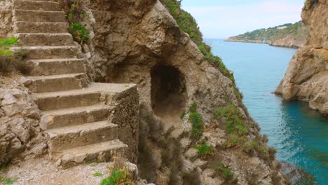 profile view of weathered stone steps carved into rugged, rocky cliff face in sicily, italy.