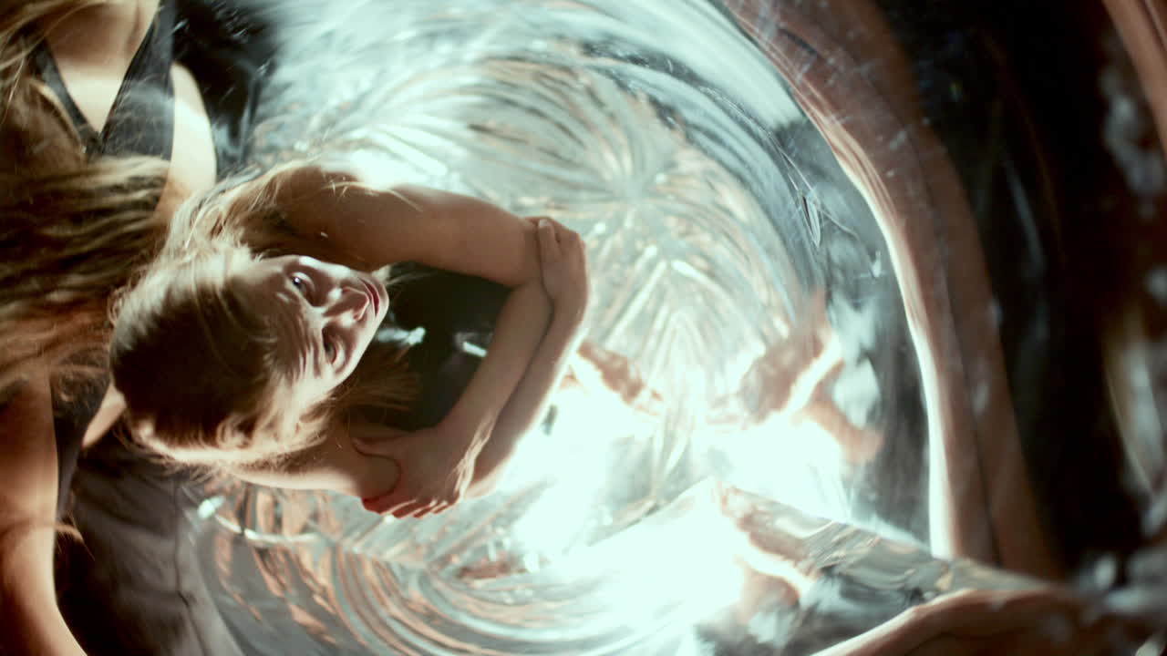 Woman Sitting on Mirrored Floor Surrounded by Swirling Distorted Reflections