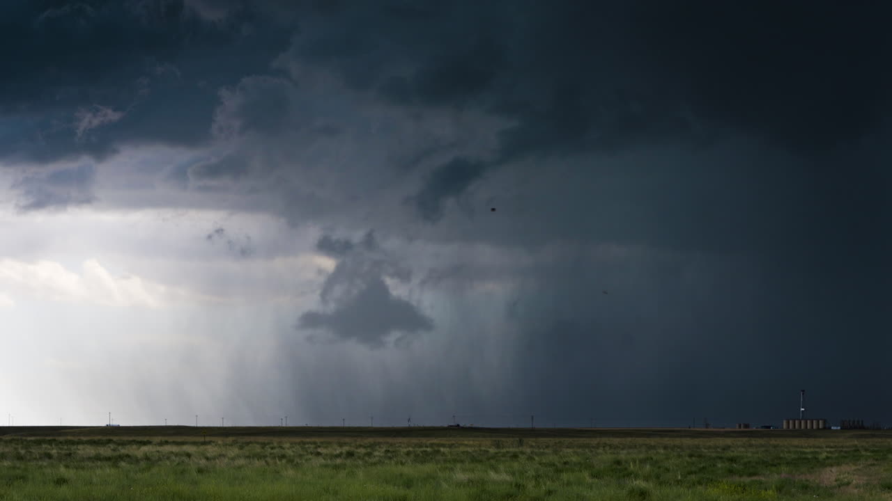 Bands of rain quickly moving beneath a dark storm