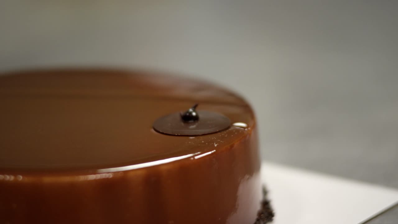 la mano sumergiendo el crujido dorado en el ganache de chocolate suave, detalle de primer plano, momento de postre indulgente