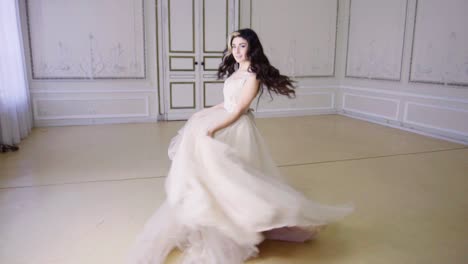 young woman in long evening dress dances in a hall