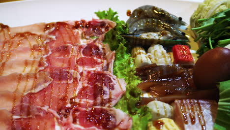 ingredientes shabu como carne de cerdo cruda, vegetales, huevos y mariscos