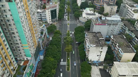 aerial tracking shot by drone of traffic on busy road sournedned by high raise building in china chengdhu