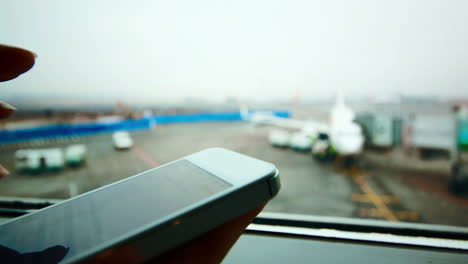 Woman-using-smart-phone-at-the-airport