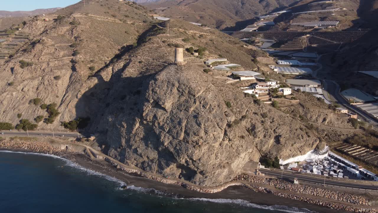 Cautor watchtower in La Mamola, Granada, Spain. Greenhouses in the valley