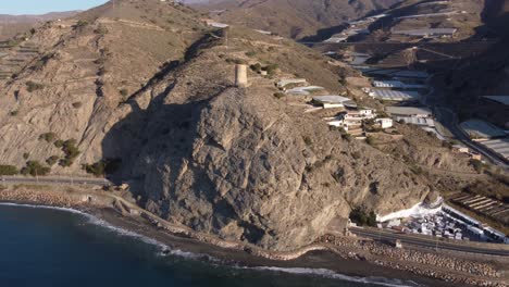 cautor watchtower in la mamola, granada, spain. greenhouses in the valley