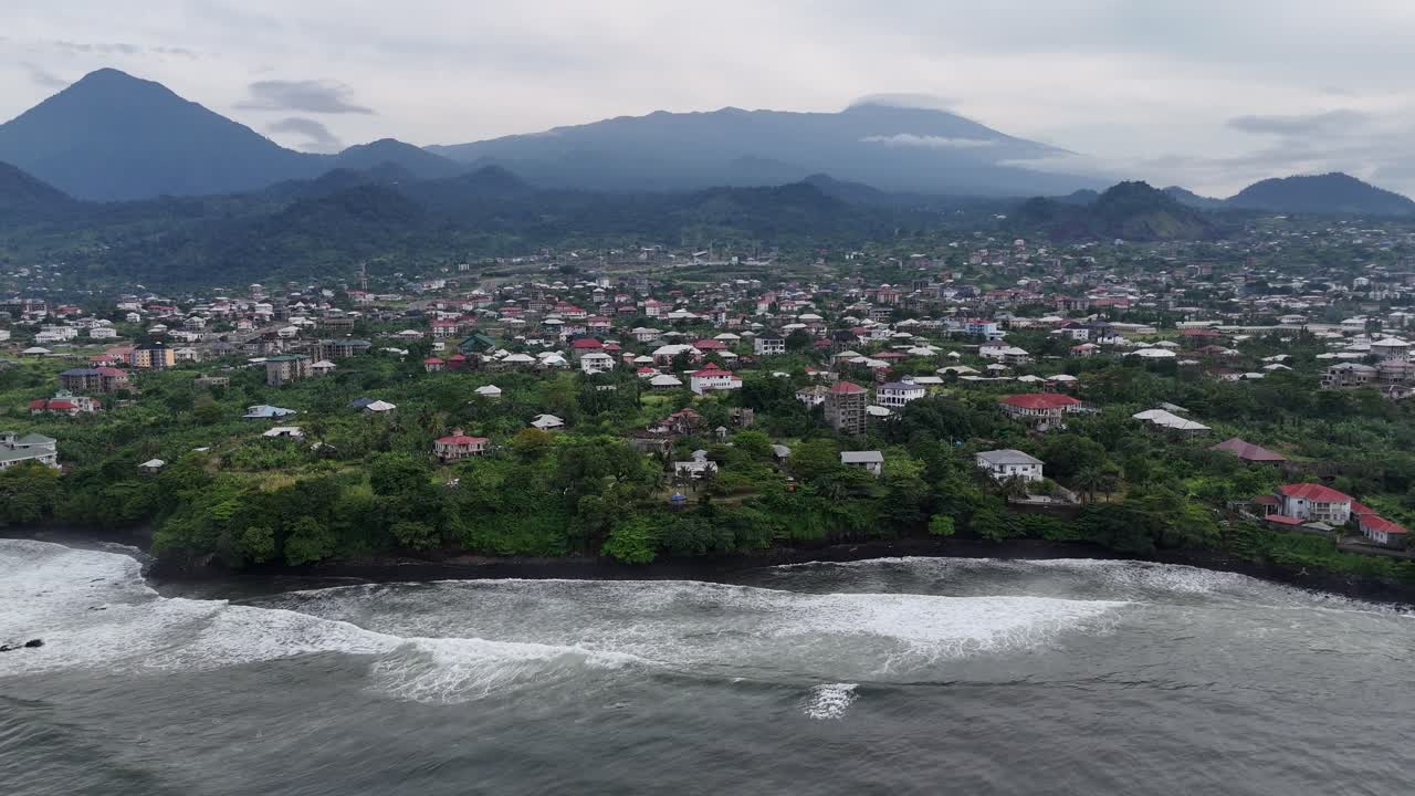 Uma vista de drone grande angular capturando a extensa cidade costeira de Limbe, Camarões, aninhada ao longo do Oceano Atlântico e exuberantes colinas verdes