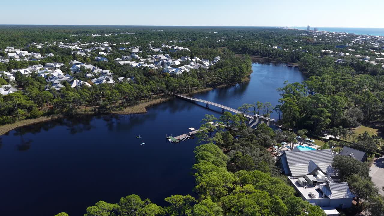Ripresa aerea orbitale con drone sopra il canale della zona occidentale del lago presso la comunità del Western Lake Park con ambiente boschivo, 30A, Florida, USA