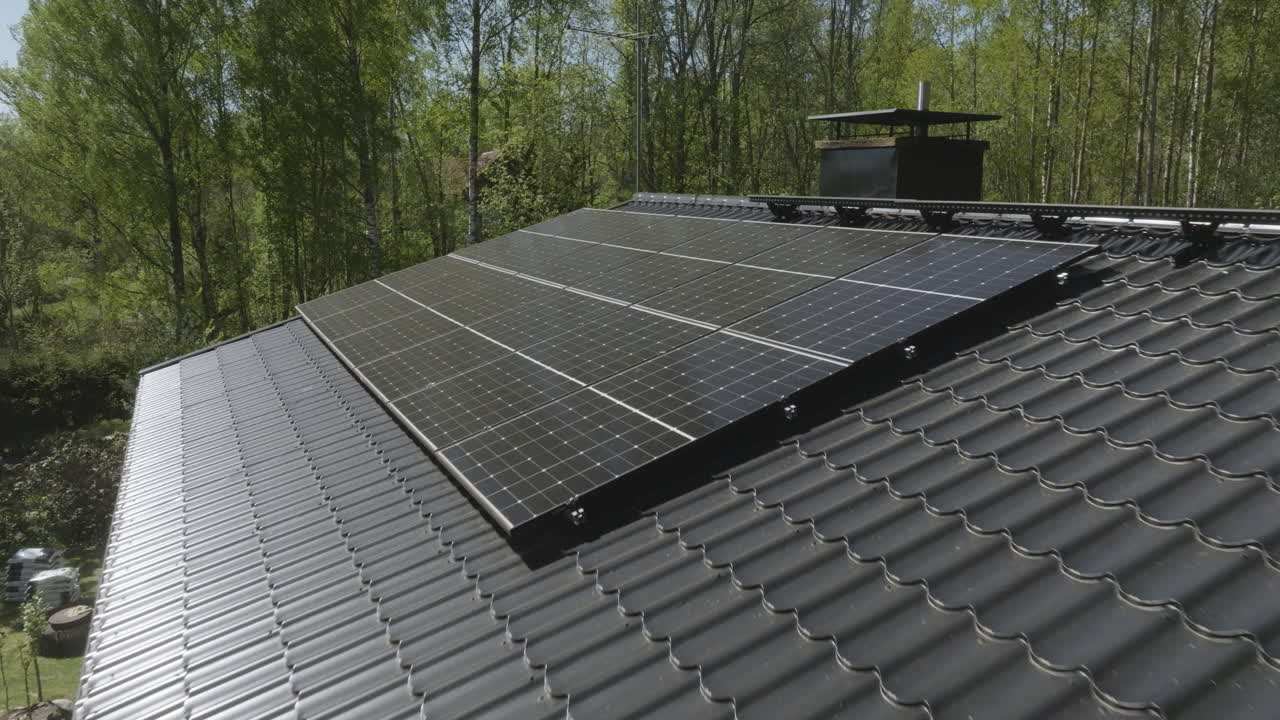 Drone shot approaching sunlight collectors on a house roof, sunny. spring day