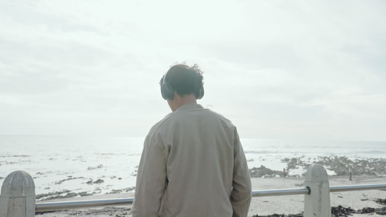 Man with Headphones Contemplating the Ocean View