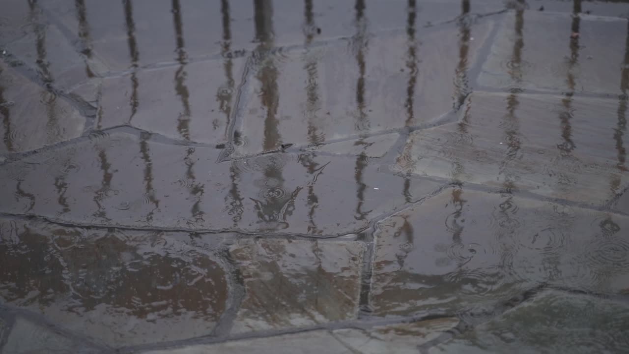 돌 타일 위에 떨어지는 비방울의 느린 움직임  ⁇