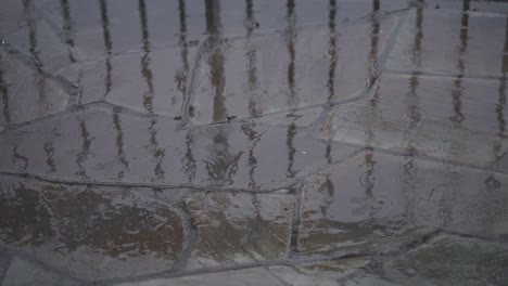 disparo en cámara lenta de gotas de lluvia cayendo sobre azulejos de piedra