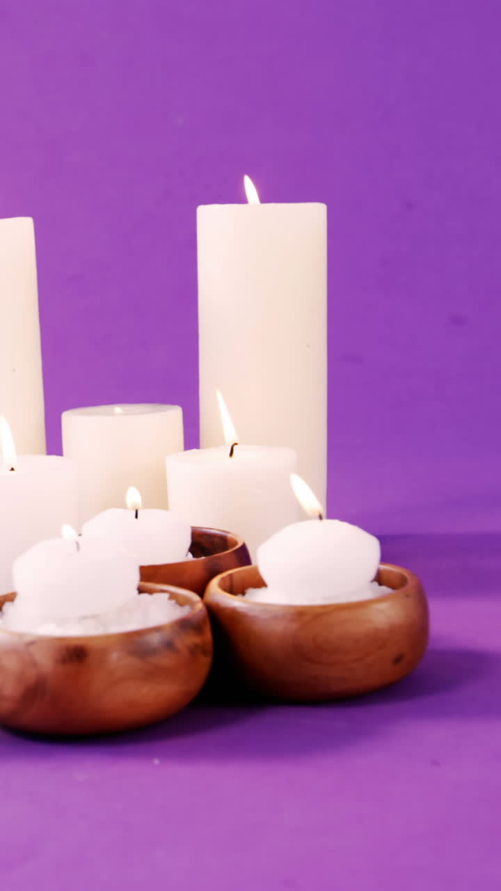 sal de mar en un cuenco de madera, aceite y velas en la mesa