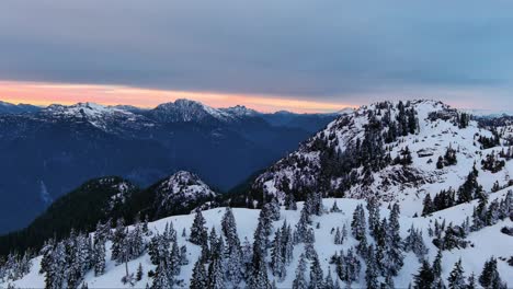 Malerische-Schneebedeckte-Berg--Und-Baumlandschaft,-Farbenfroher-Sonnenuntergangshimmel