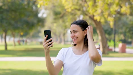 indian woman clicking selfies and photos while doing exercise in a park in morning