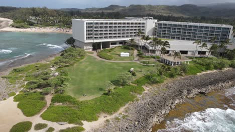 Panning-aerial-shot-of-a-beautiful-coastline-with-a-resort,-turtle-bay-coastline