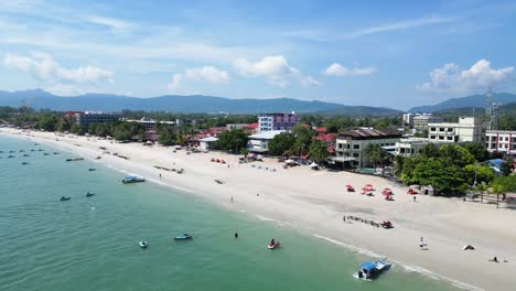 drone flight at a beach in langkawi, malaysia drone flies up, and you can see the beach with hotel buildings by the sea