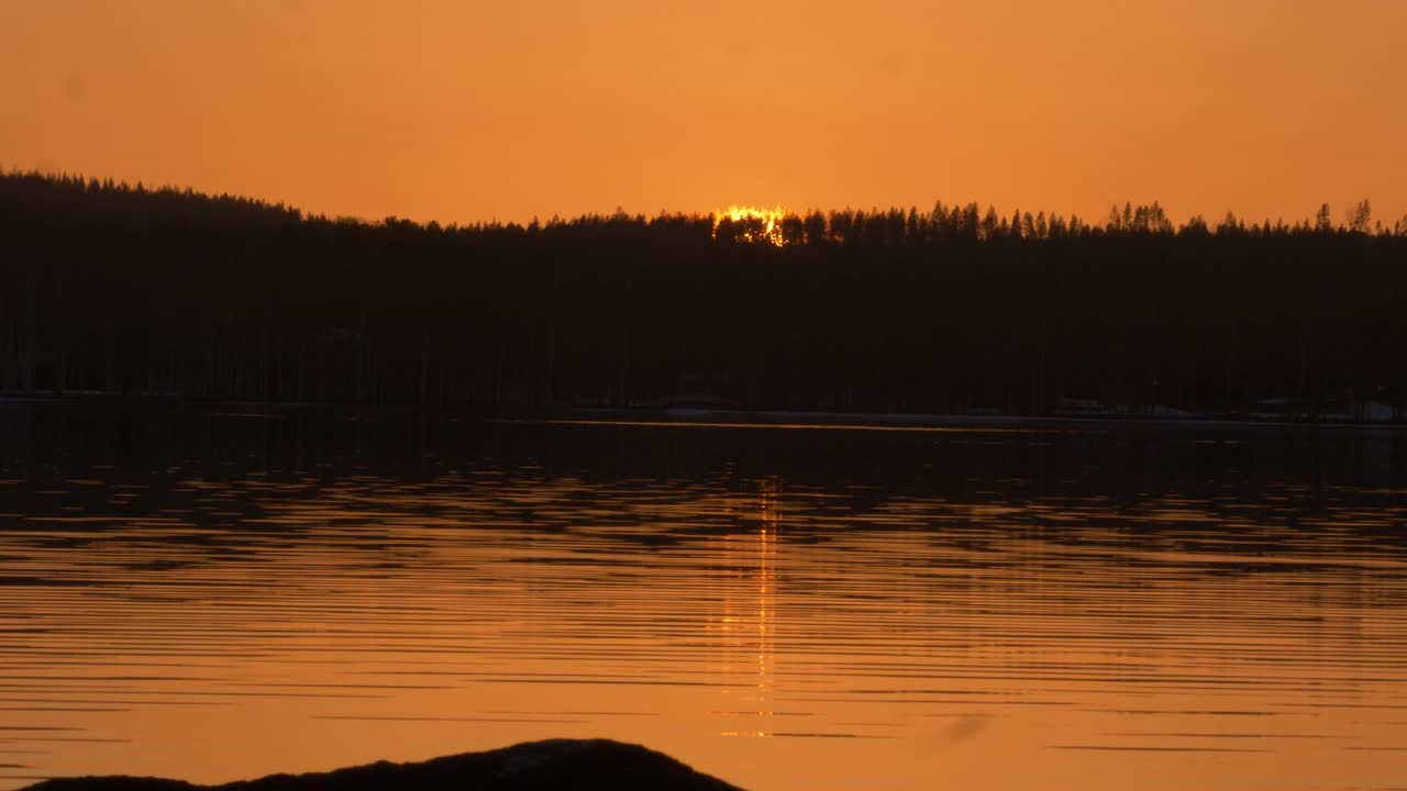 lapso de tempo da margem do rio do sol dourado se pondo atrás das colinas alpinas escuras
