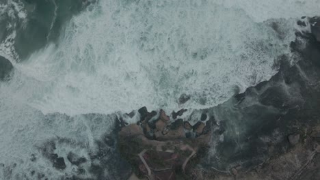 static aerial shot of sea waves moving toward to the coastline - top down view