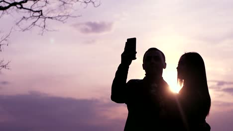 una pareja tomando una selfie al atardecer