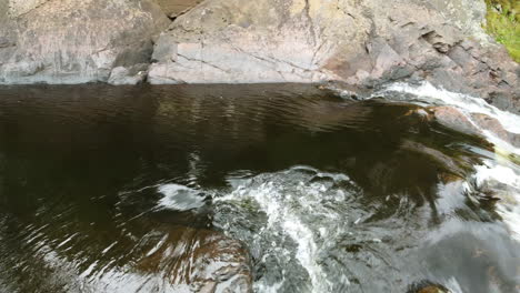 downstream with foamy water rapidly flows over rocks