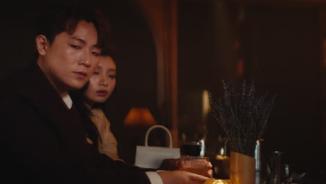 한 커플 이 술집 에서 술 을 즐기고 있다