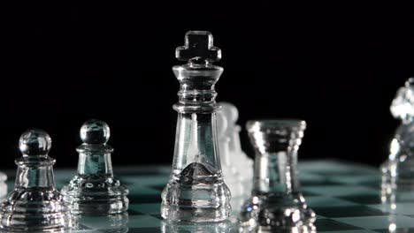 glass chess pieces on a chessboard
