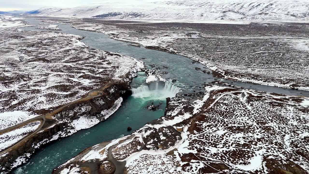 aerial wide angle river stream in snowy landscape with Waterfall of the Gods Godafoss in Iceland