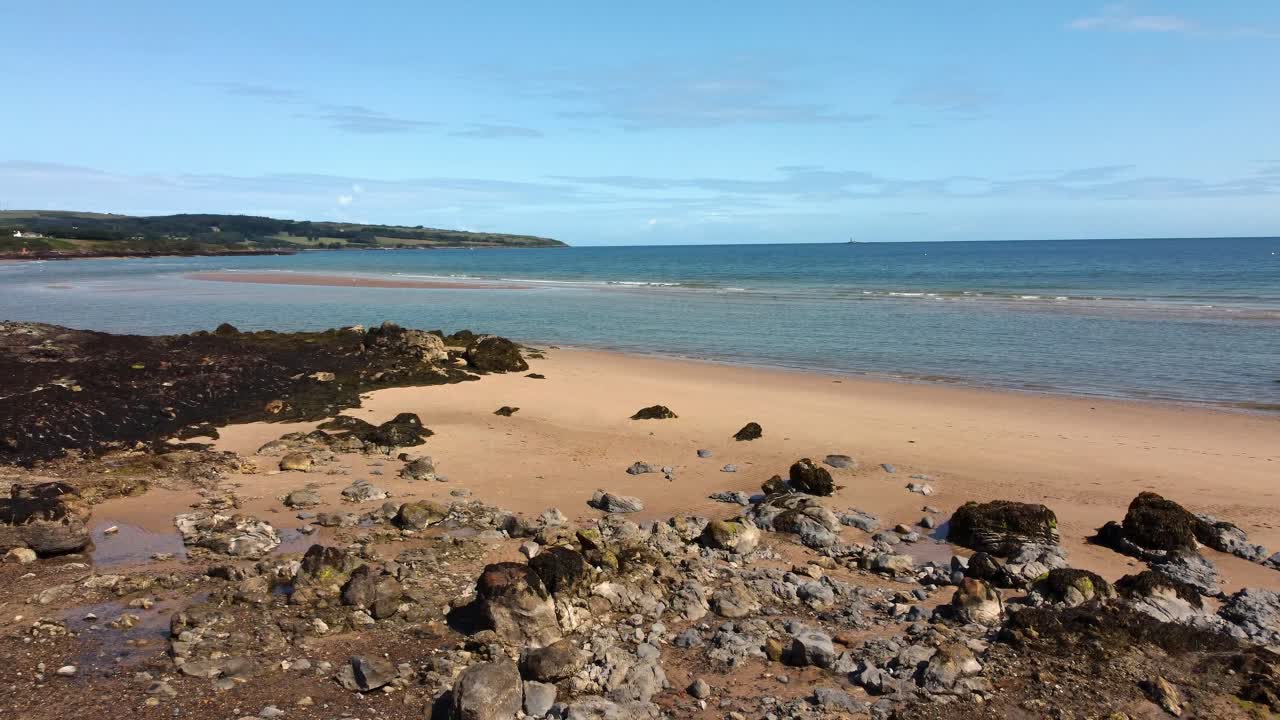 골든 로키 웨일스 해변 공중 뷰 평온한 파란 바다 파도 지평선을 가로질러 공전