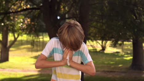 little boy blowing his nose