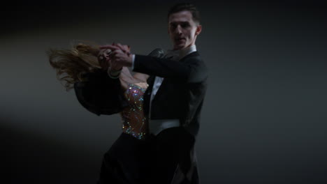 passionate dancers performing in dark hall. ballroom couple dancing indoors.