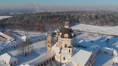 aerial view of the pazaislis monastery and the church of the visitation in kaunas, lithuania in winter, snowy landscape, italian baroque architecture, flying around the monastery, close to it