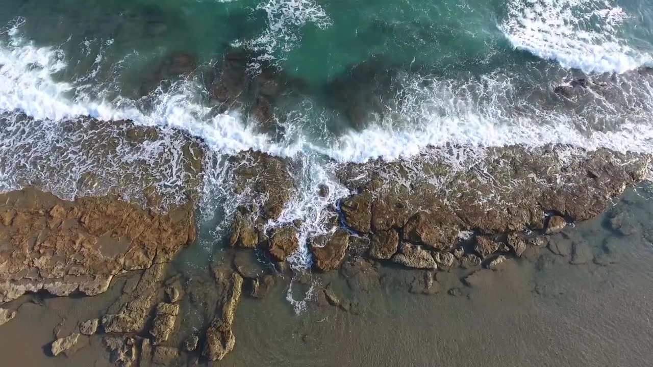 Vista aerea delle onde dell'oceano che si schiantano contro la costa rocciosa