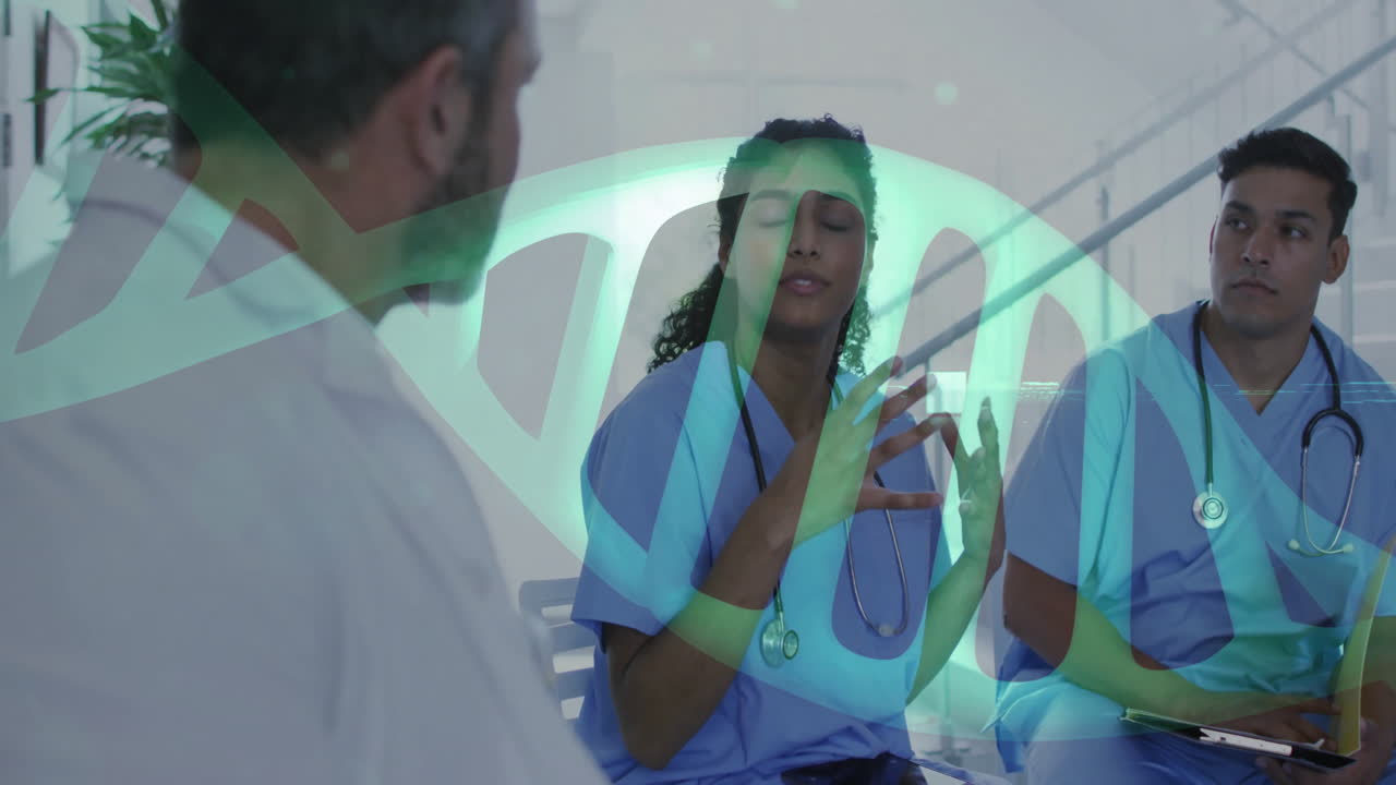 Medical team in blue scrubs discussing case in clinic area, displaying animated DNA double helix