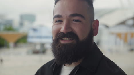 Hombre-Barbudo-Con-Sonrisa-Dentuda-Mirando-A-La-Cámara.