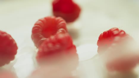 frambuesas rojas rodeadas de humo giran alrededor de un plato