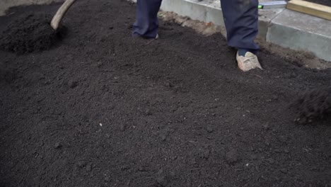 Gardener-Spreading-Topsoil-On-The-Garden-With-A-Shovel,-Close-Up-Shot