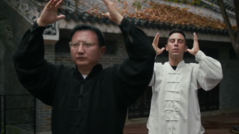 two men practicing tai chi outdoors