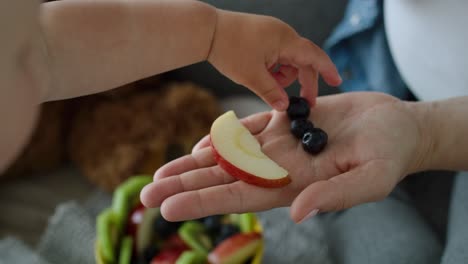 video de una madre convenciendo a su hijo bebé de que coma fruta.