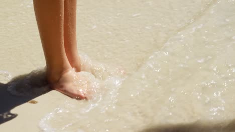 chica de pie en la orilla en la playa 4k