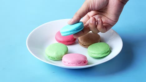 hand picking colorful macarons