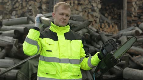 trabajador leñador. hombre leñador sostiene un gran hacha y motosierra eléctrica en sus manos. leña