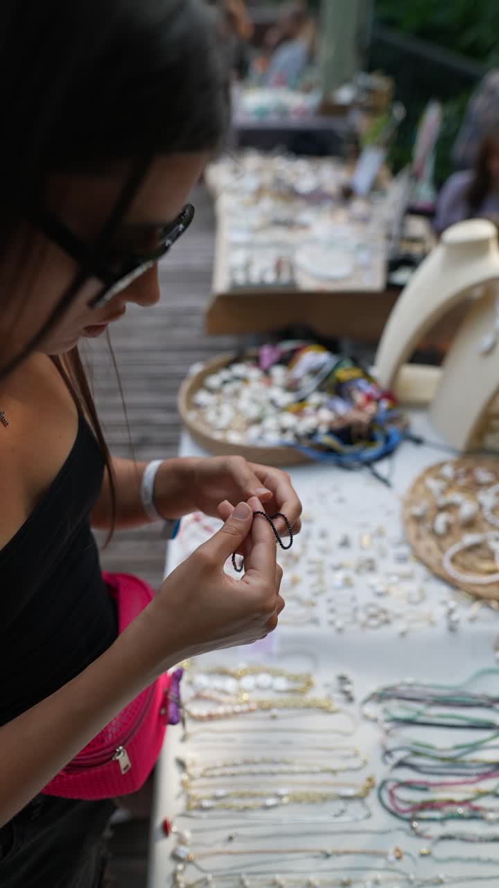 mujer mirando joyas hechas a mano en un mercado