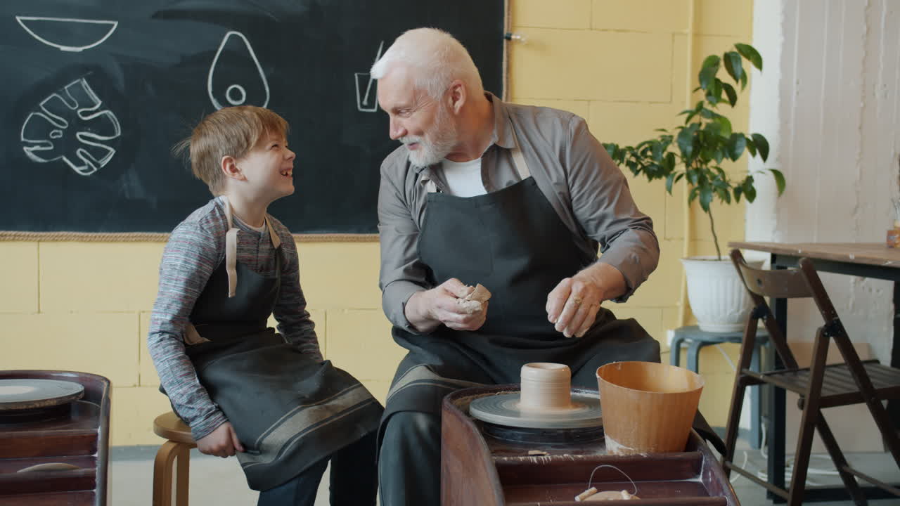 Nonno e nipote che modellano ceramica insieme