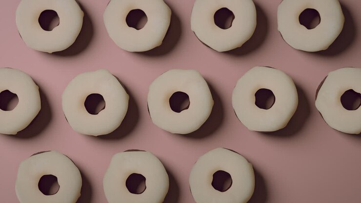 White glaze donuts on a light pink background