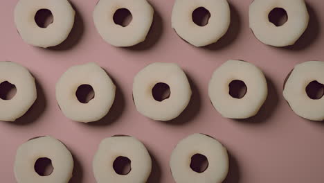 white glaze donuts on a light pink background
