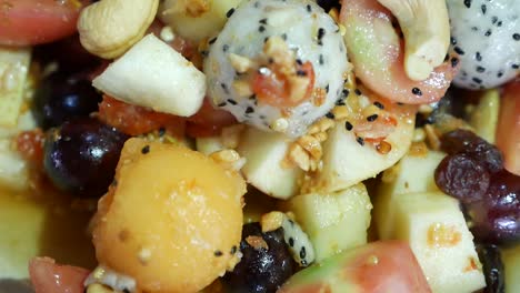 Close-Up-Footage-of-Thai-Style-Mix-Exotic-Fruits-Somtum-with-Sweet-and-Salty-Dressing-Included-Dragon-Fruit,-Cashew-Nut,-Grape,-Guava,-Melon-and-Tomato